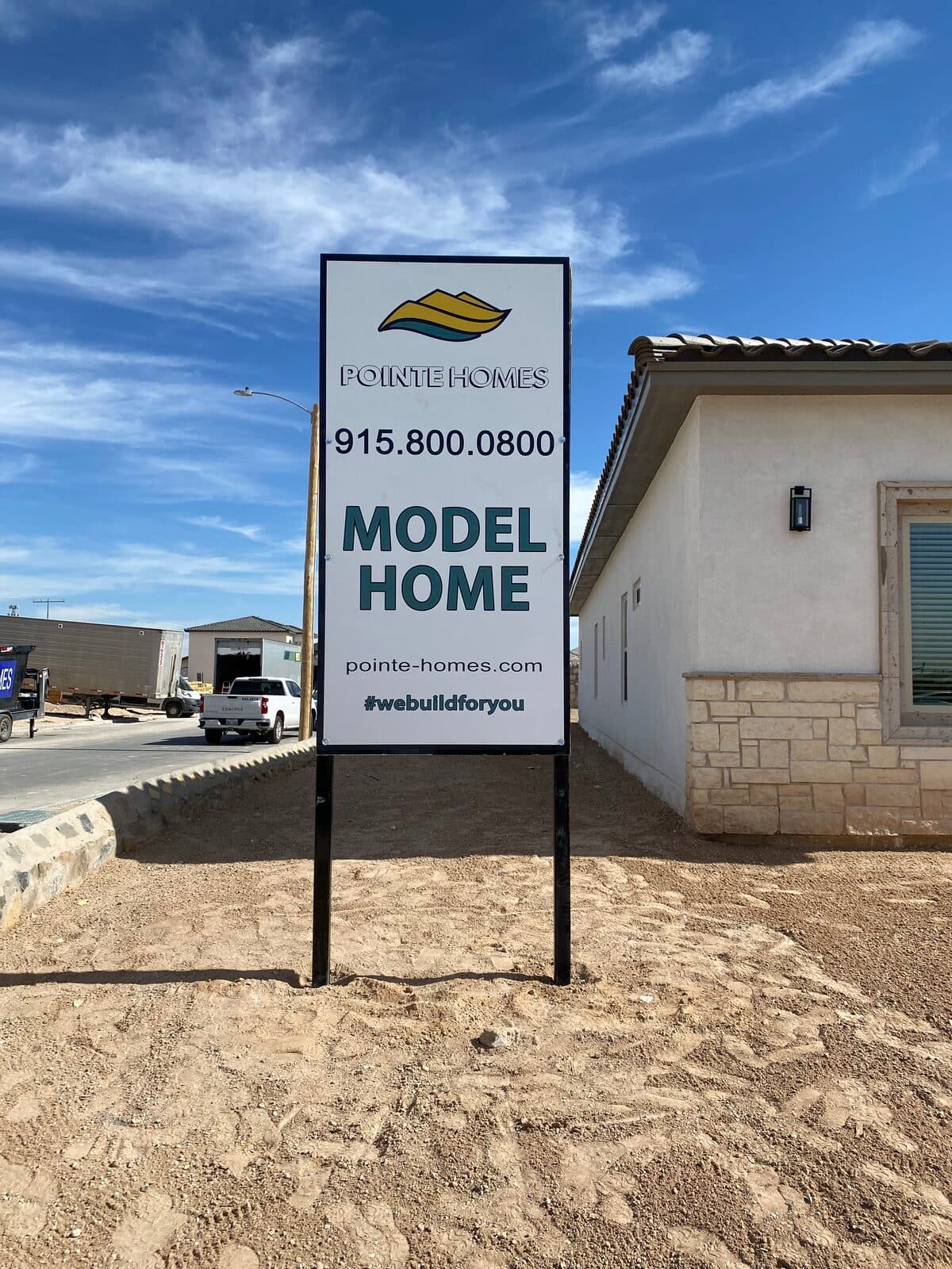 Post-mounted model home sign freshly installed at a construction site